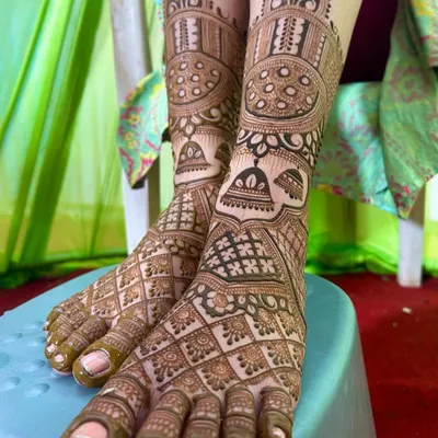 A stunningly detailed foot mehandi design, covering the feet completely with intricate patterns, including hanging jhumkas and traditional bands.