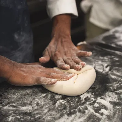 It all starts with the dough. Here, our baker is kneading sourdough by hand, a fundamental step to develop the gluten and structure for a perfect loaf.