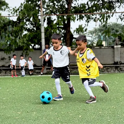 Two of our youngest players compete for the ball in a practice match, learning the basics of tackling and defending in a fun, supportive setting.