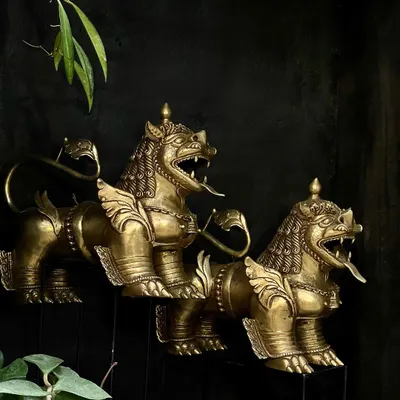 A pair of Tibetan temple lions, handcrafted from brass. These guardians are usually placed at an entrance to keep evil at bay, and their fierce expression and detailed form make them a powerful statement piece.