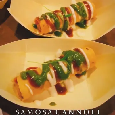 A true fusion creation, my Samosa Cannoli Chaat. A crispy cannoli shell is filled with a savoury samosa mixture and drizzled with yogurt, mint, and tamarind chutneys.