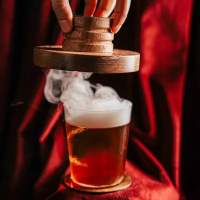 Creating atmosphere for a smoked cocktail at Amelia. We used dramatic lighting against a rich, red velvet background to highlight the billow of smoke, turning a simple drink into a theatrical experience and an unforgettable visual.