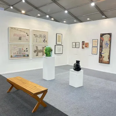 A wide view of our curated booth at Art Mumbai 2024. The display features a mix of sculptures and paintings, demonstrating the variety of mediums and styles we represent, from Archana Hande's textile-inspired works to Venkat Bothsa's sculptures.