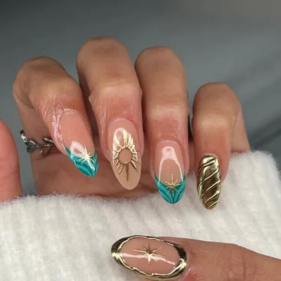 A celestial-inspired set featuring a mix of techniques. Notice the hand-painted sunburst, 3D gold sun emblem, and sculpted gold textures, all combined to create a truly unique and artistic manicure.