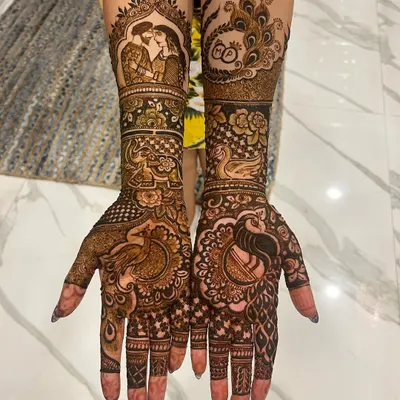 I love bringing a couple's story to life with my mehendi. This detailed engagement design features a custom portrait, graceful peacocks, and the couple's initials hidden within the artwork.