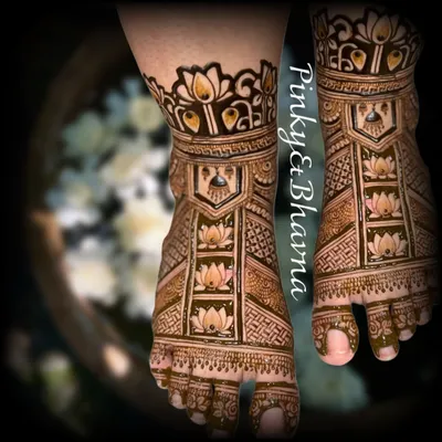 A close up of beautifully adorned bridal feet. This design features lotus motifs inside geometric patterns, creating a look that is both traditional and neat.