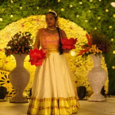 A dancer in traditional attire holds lotus-shaped diyas, ready to perform a welcome dance. This classic performance adds a touch of grace and auspiciousness to any wedding event.