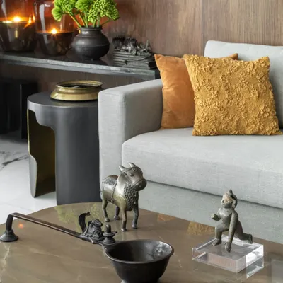 A close-up on a coffee table reveals the quiet choreography of objects. Here, antique bronze sculptures from our personal collection sit alongside contemporary furniture, telling a story that spans time and geography. These details are what give a space its soul.
