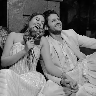 A joyful, candid black and white shot from an editorial pre-wedding shoot with actress Surbhi Chandna and Karan Sharma. This image captures their natural chemistry and happiness.