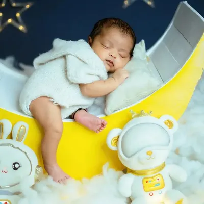 A full view of the 'Blue Moon' newborn setup. The glowing moon prop, soft cotton clouds, and hanging stars create a magical backdrop for your baby's first professional portraits.