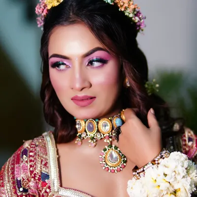 A vibrant and colorful Mehendi look. We used bright pink eyeshadow to match the playful vibe of the event, paired with a floral hair crown.