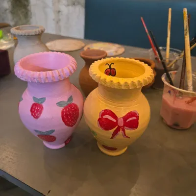 Look at these adorable creations. After you've shaped your piece, you get to bring it to life with color. These two hand-painted vases show just how personal you can make your art.