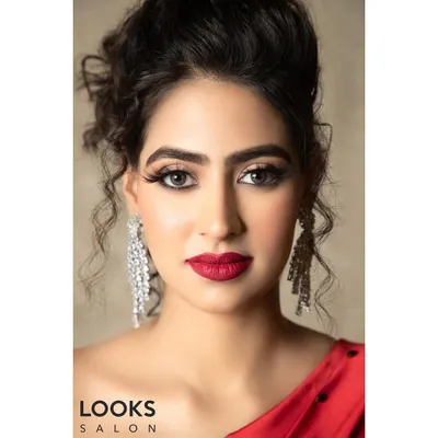 A classic party look featuring a bold red lip and defined eyes. This close-up shows the flawless base and crisp eyeliner, a timeless combination that exudes confidence and glamour for any evening event.