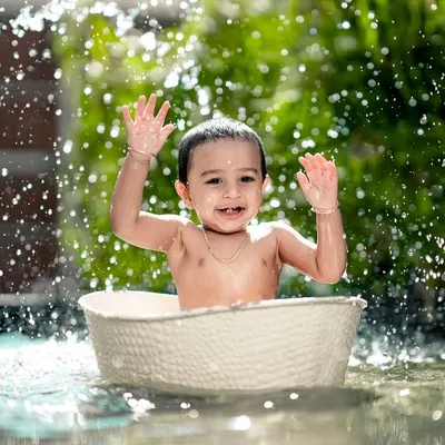 Pure happiness in a splash! This little one is having the time of his life in our water tub, creating a perfect action shot.