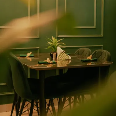 A view of the dining setup at my restaurant. The elegant green decor and comfortable seating create a welcoming atmosphere.