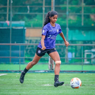 A player dribbling with focus and control during a match. This showcases the technical skill we instill in our players.