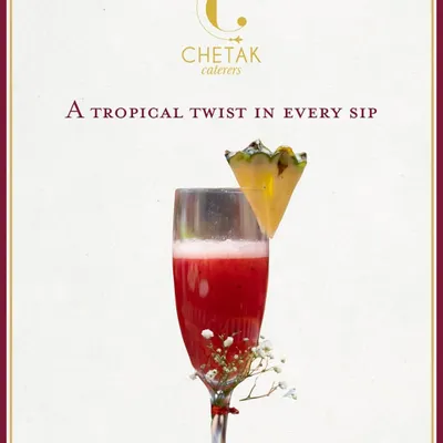 A tropical twist in every sip. This vibrant red mocktail, garnished with a slice of pineapple, is a refreshing and elegant welcome drink for any celebration.