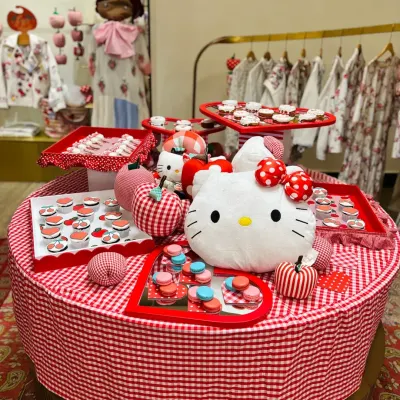 The full grazing table I curated for the Hello Kitty x Péro showcase at Good Earth. The setup features custom cupcakes, macarons, and other themed treats arranged on a red-and-white gingham tablecloth.
