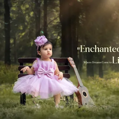 A little girl dressed as a princess sits on a bench in an enchanted forest setting. This portrait uses a ukulele prop and dreamy lighting to create a magical childhood photo.