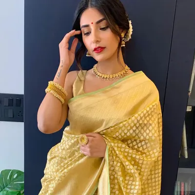 The beautiful actress Harshita Gaur, ready for a friend's wedding. We created a perfect day look with minimalist gold eyes, a classic red lip, and a messy bun with gajra to complement her golden saree.