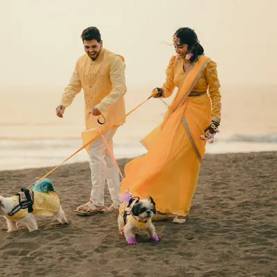 A joyful shot of a couple walking their two adorable dogs on the beach. This photo is full of happiness and shows how we can include your pets in your pre-wedding story.