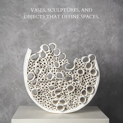 This intricate white ceramic sculpture is a testament to artistry. Its complex, cellular structure creates a captivating play of light and shadow, making it a defining object for any modern space.