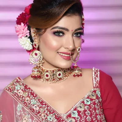 A beautiful glam look with a floral bun. The makeup is bright and festive, perfect for any celebration.
