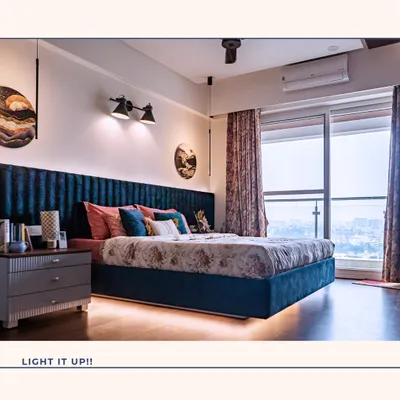 Lighting is key to creating a luxurious atmosphere. This bedroom features a stunning blue velvet channelled headboard with integrated under-bed lighting and elegant pendant lights, creating a soft, ambient glow perfect for winding down.
