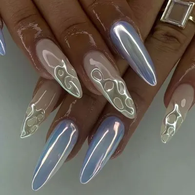 An iridescent chrome finish on long stiletto nails. This set features a mix of full chrome and 3D flame outlines for a futuristic look.