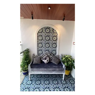 We created a beautiful focal point on this balcony with a Moroccan-inspired tile pattern set within an arched wall niche. The ornate bench and vibrant blue floor tiles come together to create a cozy and picturesque seating area.