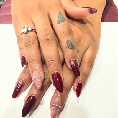 A beautiful set of deep red almond nails. I combined the solid color with accent nails featuring pink glitter and a rhinestone band, giving a classic manicure a modern, glamorous twist.