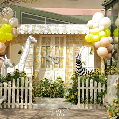Welcome to the Sunlit Safari. We created this cheerful yellow gingham house as the centerpiece, surrounded by friendly animal props and bright sunflowers for a first birthday.