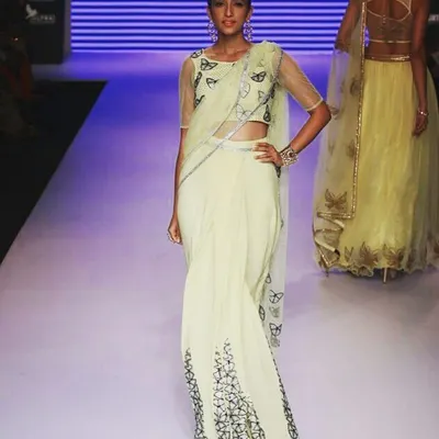A highlight from a runway show I styled. This modern saree features intricate butterfly motifs and sparkling Swarovski crystals, demonstrating my ability to blend traditional elements with high-fashion runway presentation.