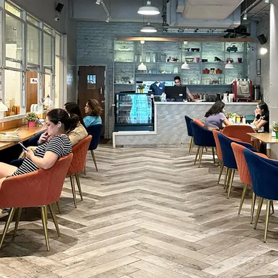 I designed the cafe to be a stylish and comfortable retreat for parents. With modern herringbone floors, cozy chairs, and a clear view of the play area, it's a space where you can truly unwind.