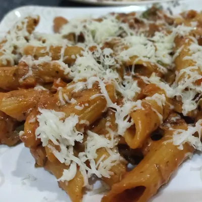 A delicious plate of penne pasta in a rich red sauce, generously topped with grated cheese. A classic Continental dish that everyone loves.
