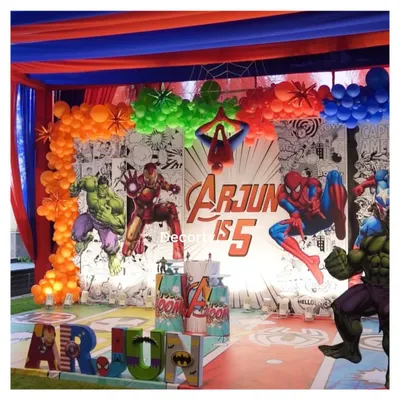 An explosive Avengers-themed stage backdrop for Arjun's 5th birthday. It features a comic-book style background, character cutouts, and personalized 3D letters.