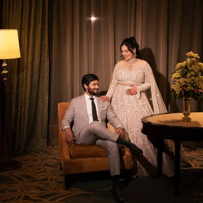 An elegant reception portrait of the couple in a luxurious hotel room, showcasing their sophisticated style. I use the ambient light to create a warm, intimate mood.