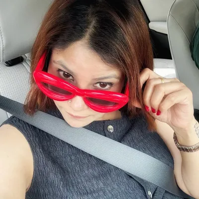 Accessories can be the main event. These quirky, oversized red sunglasses add a dose of fun and chaos to an otherwise calm and neutral outfit, proving that a single accessory can change your entire vibe.