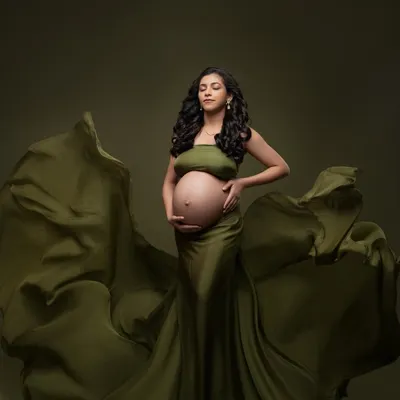 A moment of quiet reflection in our stunning olive green gown. The fabric drapes and flows, creating a beautiful silhouette against the matching backdrop for a powerful, monochromatic fine art portrait.