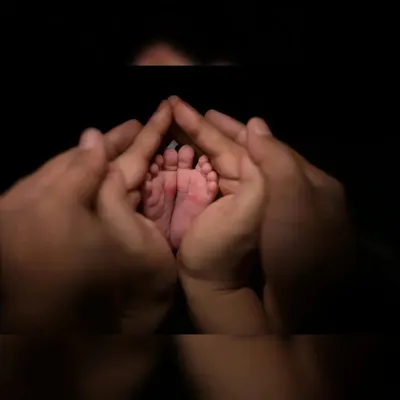 There is nothing more precious than tiny newborn feet. I use focused lighting to capture these delicate details, framed by the parents' hands to show scale and love.
