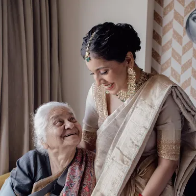 A priceless moment of love between generations. The bride shares a warm, genuine smile with her grandmother, a memory to be treasured forever.