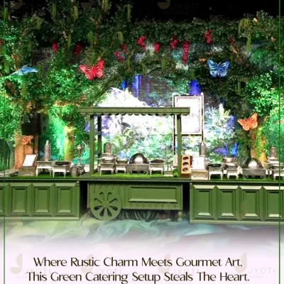 A rustic-themed catering setup where lush greenery and butterfly details create an enchanting forest feel. The green wooden cart and counters blend seamlessly with the natural decor.