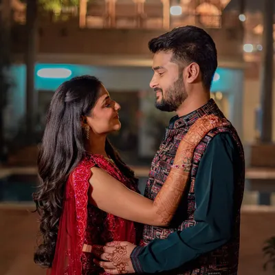 A romantic portrait of Ashri and Nayan during their Sangeet night. The warm lighting and their close embrace create a beautiful, intimate moment amidst the celebration.