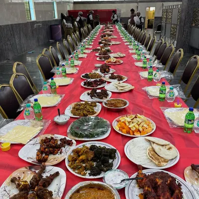 A complete Dastarkhwan setup ready for a wedding reception. The long table is laden with a variety of our best dishes, including multiple chicken starters, mutton curries, fruit salad, and fresh bread, ensuring a feast for the eyes and the palate.