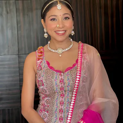 A perfect Mehendi look. This bride is glowing with happiness. We kept the makeup minimal and fresh, with a pretty pink lip to match her vibrant outfit.