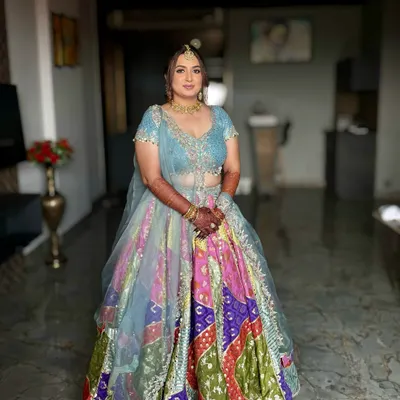 A beautiful Haldi look for Dhruvi. The makeup is fresh and minimal, with a pop of color on the eyes to complement her vibrant, multi-colored lehenga.