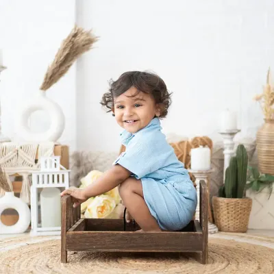 That happy smile is what we live for. This portrait was taken in our bohemian-style studio setup, which provides a neutral and warm background for toddler photos.