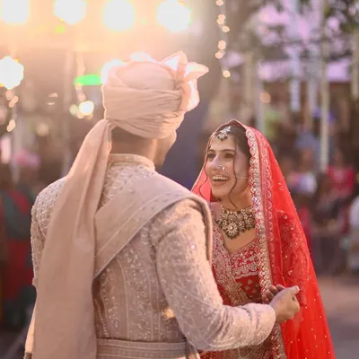 A candid moment of pure happiness between the bride and groom. Her makeup was designed to look radiant and fresh even in the soft evening light, with a focus on glowing skin and defined eyes.