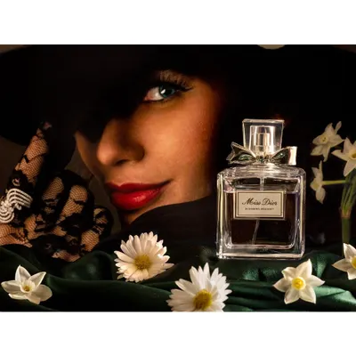 A campaign-style product shot for Dior perfume. The image combines a model's mysterious gaze with the elegance of the product, creating a narrative of luxury and desire.