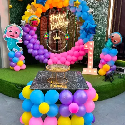 This Cocomelon themed first birthday party is one of my popular requests. It includes a colorful balloon ring, Cocomelon character cutouts, and a light-up number '1' for the special milestone.